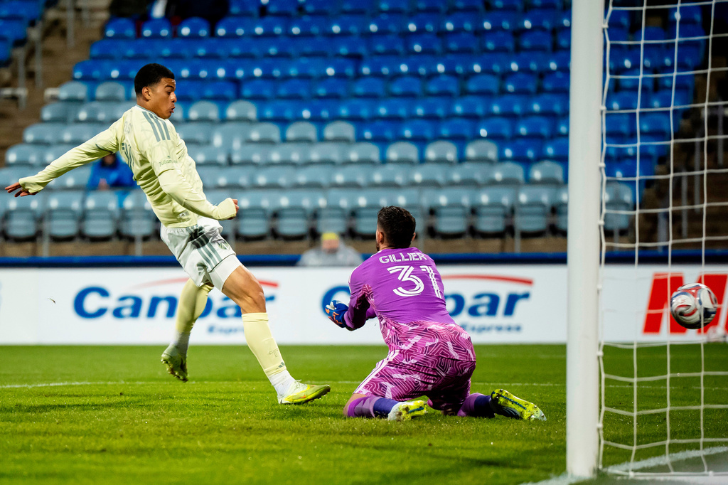 Portland Timbers' Kevin Kelsy, left, scores on CF Montreal goalkeeper Thomas Gillier (31) during the first half of an MLS soccer game in Montreal on Wednesday, May 13, 2026. (Christopher Katsarov/The Canadian Press via AP)