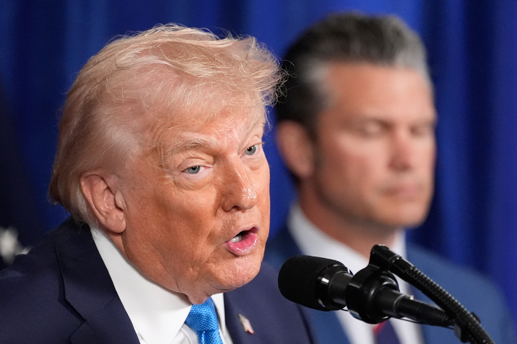President Donald Trump speaks at his Mar-a-Lago club, Saturday, Jan. 3, 2026, in Palm Beach, Fla., as Defense Secretary Pete Hegseth listens. (AP Photo/Alex Brandon)