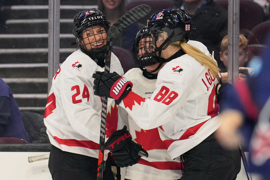 Canada's Natalie Spooner (24) and Julia Gosling (88) celebrate a goal by Sarah Fillier, center, in the first period of a Rivalry Series women's hockey game against the United States, Thursday, Nov. 6, 2025, in Cleveland. (AP Photo/Sue Ogrocki)