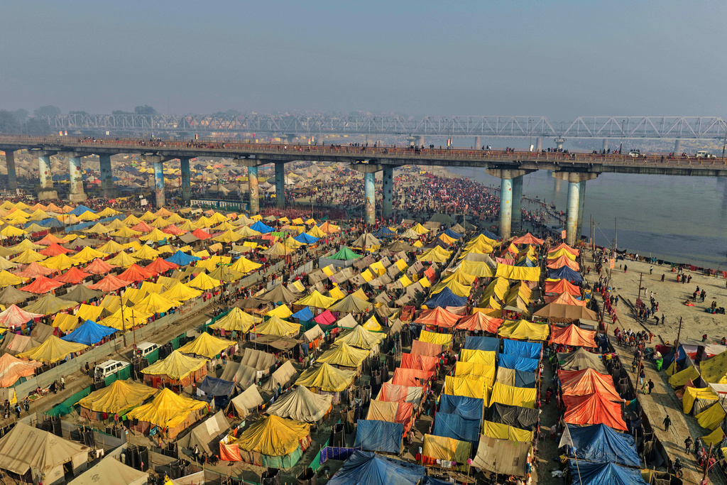 Devotees arrive for a holy dip on Mauni Amavasya, a divine occasion in Hindu religious practice followed for honoring ancestors or forefathers, at the Sangam, the confluence of the Ganges, the Yamuna and the mythical Saraswati rivers, during the annual month long Hindu religious fair "Magh Mela" in Prayagraj, India,Sunday, Jan. 18, 2026. (AP Photo/Rajesh Kumar Singh)