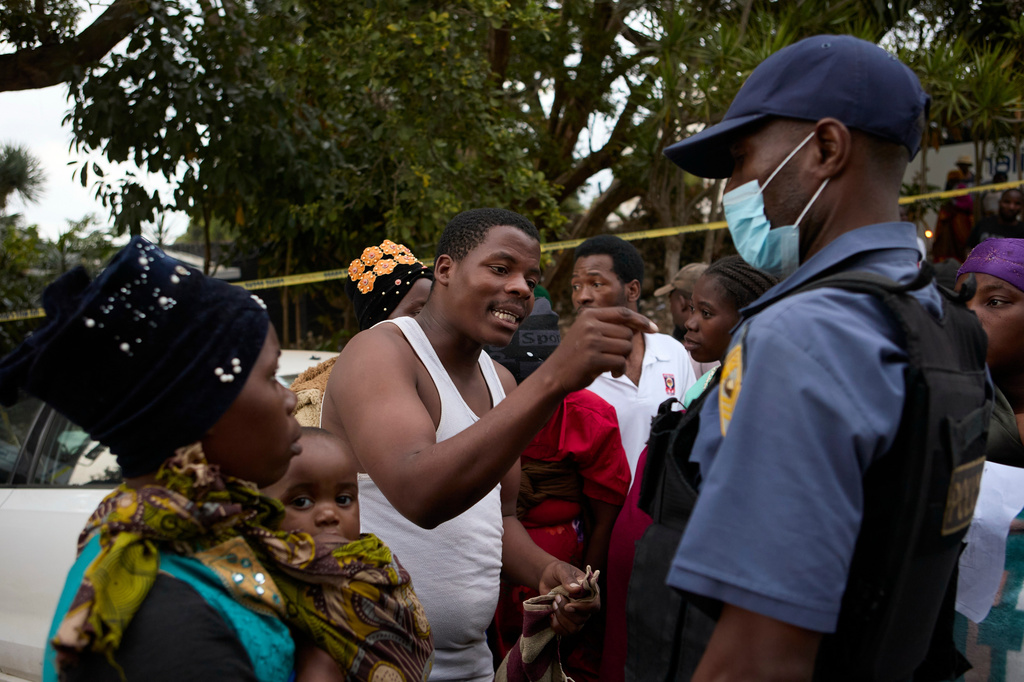 Malawian man talks to a police officer after clashes with police at a deportation site, in Durban, South Africa, Wednesday, June 17, 2026. (AP Photo)