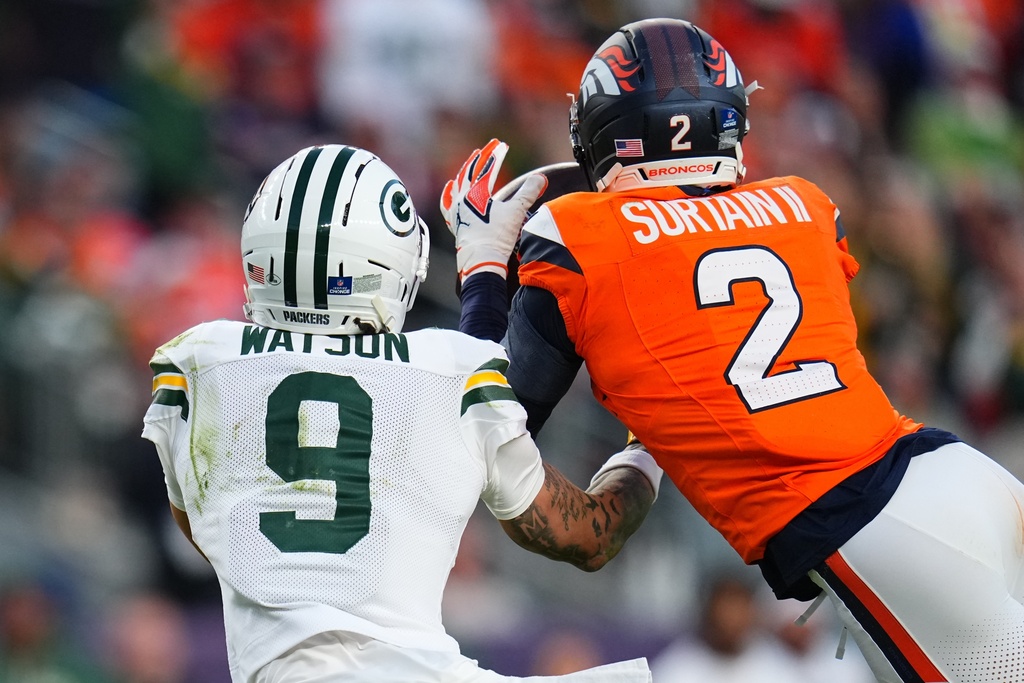 Denver Broncos' Pat Surtain II intercepts a pass in front of Green Bay Packers' Christian Watson during the second half of an NFL football game Sunday, Dec. 14, 2025, in Denver. (AP Photo/Jack Dempsey)