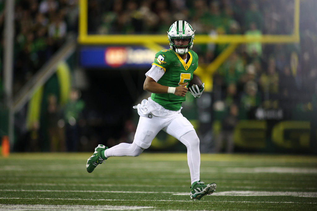 Oregon quarterback Dante Moore (5) runs with the ball during the first half of an NCAA college football game against Minnesota, Friday, Nov. 14, 2025, in Eugene, Ore. (AP Photo/Lydia Ely)