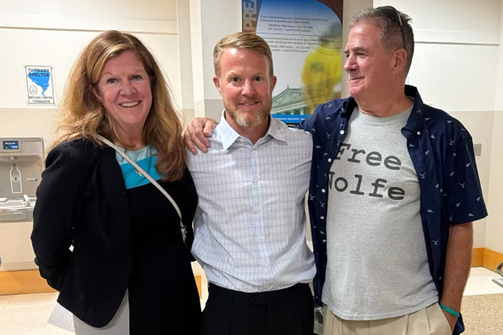 In this photo taken with a smartphone and provided by Erin Wolfe, Justin Wolfe, center, stands with his mother Terri Steinberg, left, and uncle Joe Casamento at the Prince William County Jail, shortly after Justin's release Monday, Sept. 28, 2026, in Manassas, Va. (Erin Wolfe via AP)