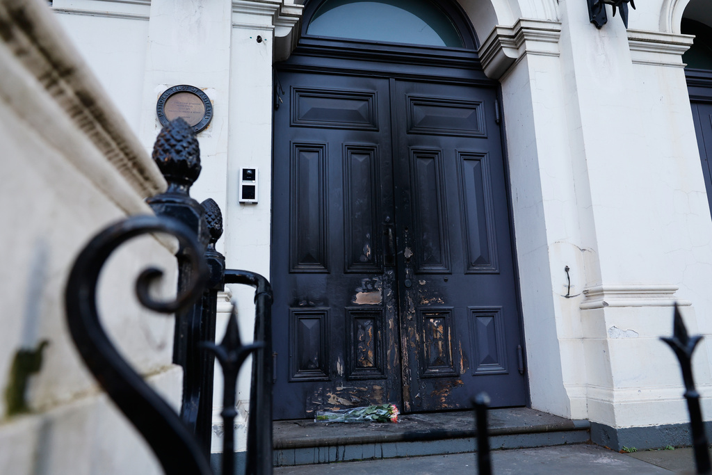 Flowers are left at the fire-damaged door of the East Melbourne Synagogue in Melbourne, Australia, July 7, 2025, following an arson attack. (Con Chronis/AAP Image via AP)