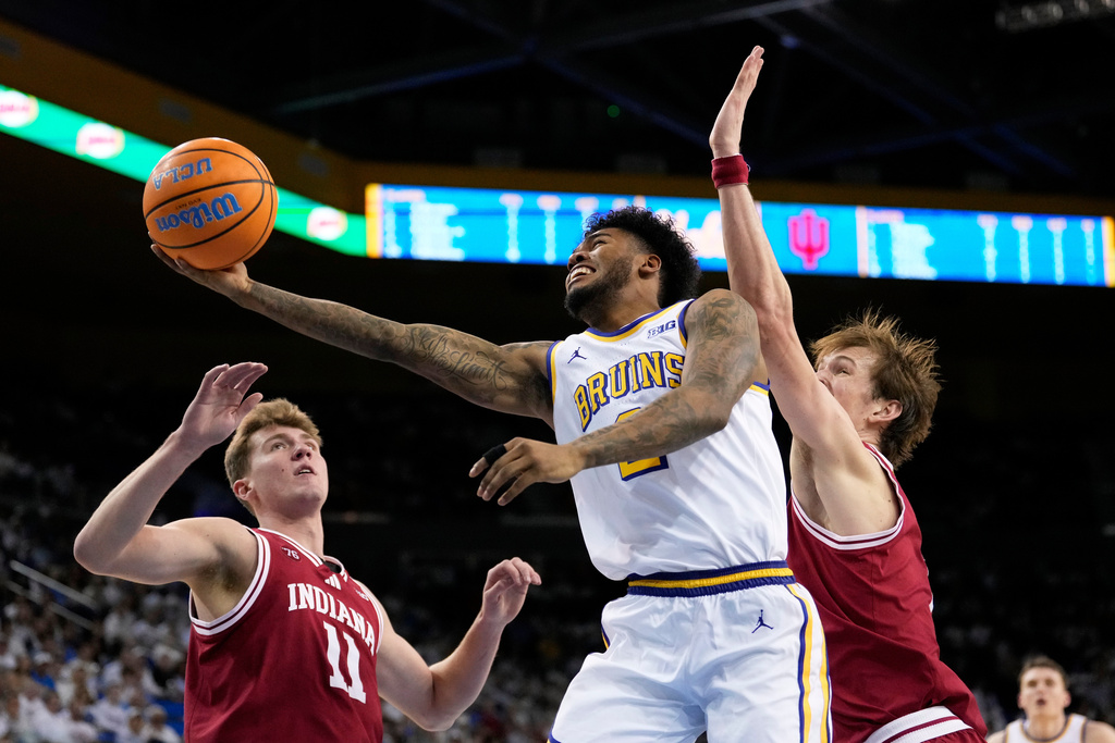UCLA guard Donovan Dent, center, shoots as Indiana forward Trent Sisley, left, and forward Reed Bailey defend during the second half of an NCAA college basketball game, Saturday, Jan. 31, 2026, in Los Angeles. (AP Photo/Mark J. Terrill)