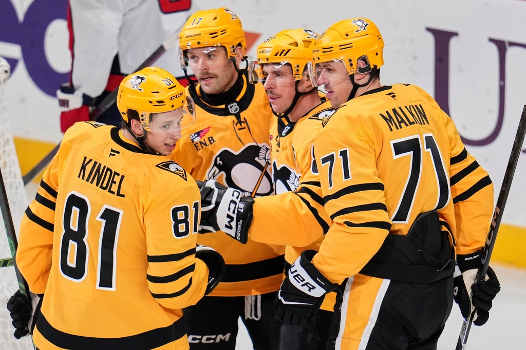 Pittsburgh Penguins' Sidney Crosby, second from right, celebrates his second goal of the first period with Evgeni Malkin (71), Bryan Rust (17) and Ben Kindel (81) during an NHL hockey game against the Washington Capitals in Pittsburgh, Thursday, Nov. 6, 2025. (AP Photo/Gene J. Puskar)