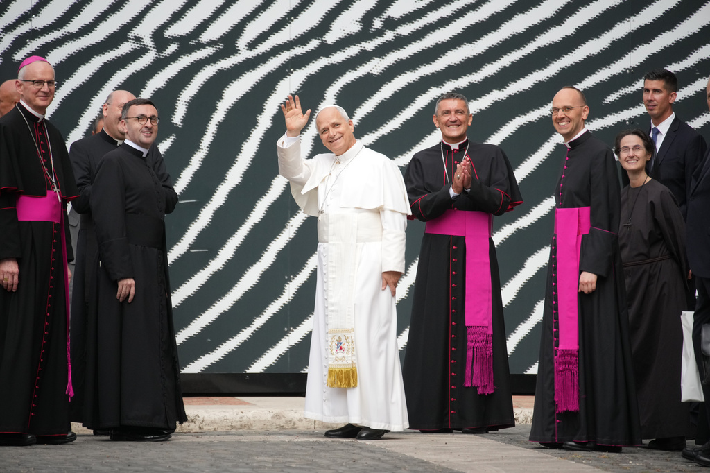 Pope Leo XIV, center, waves as he arrives with Bishop Giacomo Cardinali, vice prefect of the Vatican Library, fifth from left, Prefect of the Papal Household, Archbishop Petar Rajič, first at left, and President of the Pontifical Commission and Governorate of Vatican City State sister Raffaella Petrini, second from right, at the Vatican Library, Monday, Sept. 14, 2026, during a press preview of the exhibit "AQVA," which will be open to the public from Sept. 25 through May 14, 2027. (AP Photo/Andrew Medichini)