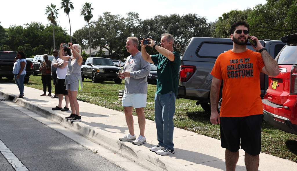 Coral Springs residents wait to enter their neighborhood after a plane crashed in the Windsor Bay community in Coral Springs on Monday, Nov. 10, 2025. (Carline Jean/South Florida Sun-Sentinel via AP)