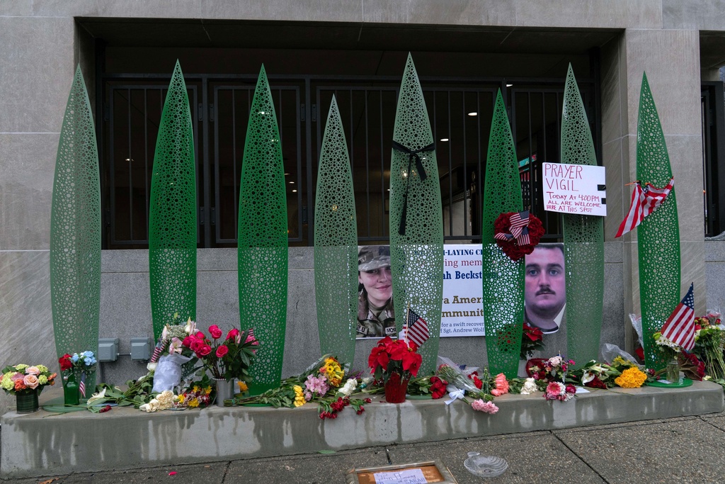A makeshift memorial of flags, flowers and other items is seen Sunday, Nov. 30, 2025, outside of Farragut West Station, near the site where two National Guard members were shot in Washington. (AP Photo/Jose Luis Magana)