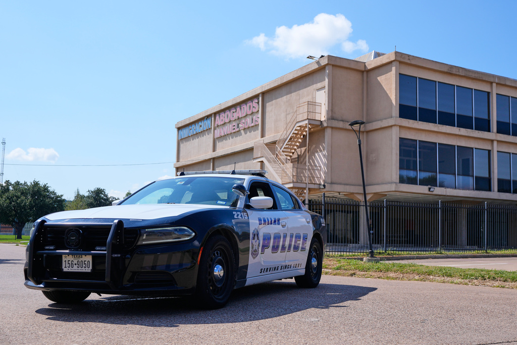A Dallas police officer's vehicle blocks the road near a crime scene by a U.S. Immigration and Customs Enforcement office Thursday, Sept. 25, 2025, in Dallas. (AP Photo/Tony Gutierrez)