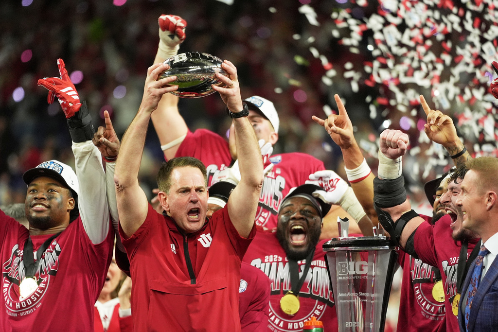 FILE - Indiana head coach Curt Cignetti holds up the championship trophy after the Big Ten championship NCAA college football game against Ohio State in Indianapolis, Saturday, Dec. 6, 2025. (AP Photo/Michael Conroy, File)