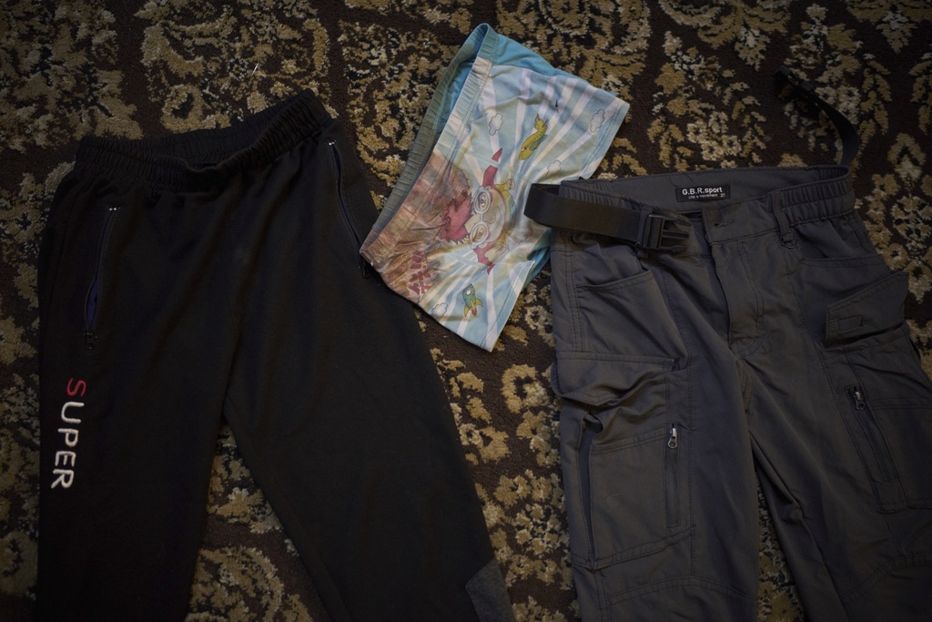 Blood-stained underwear and trousers, which Anwar al-Heimouni says were worn by her 12-year-old son, Ayman al-Heimouni, when he was killed by Israeli fire, are laid out for a picture in a room of their home in the West Bank city of Hebron, March 26, 2025. (AP Photo/Leo Correa)
