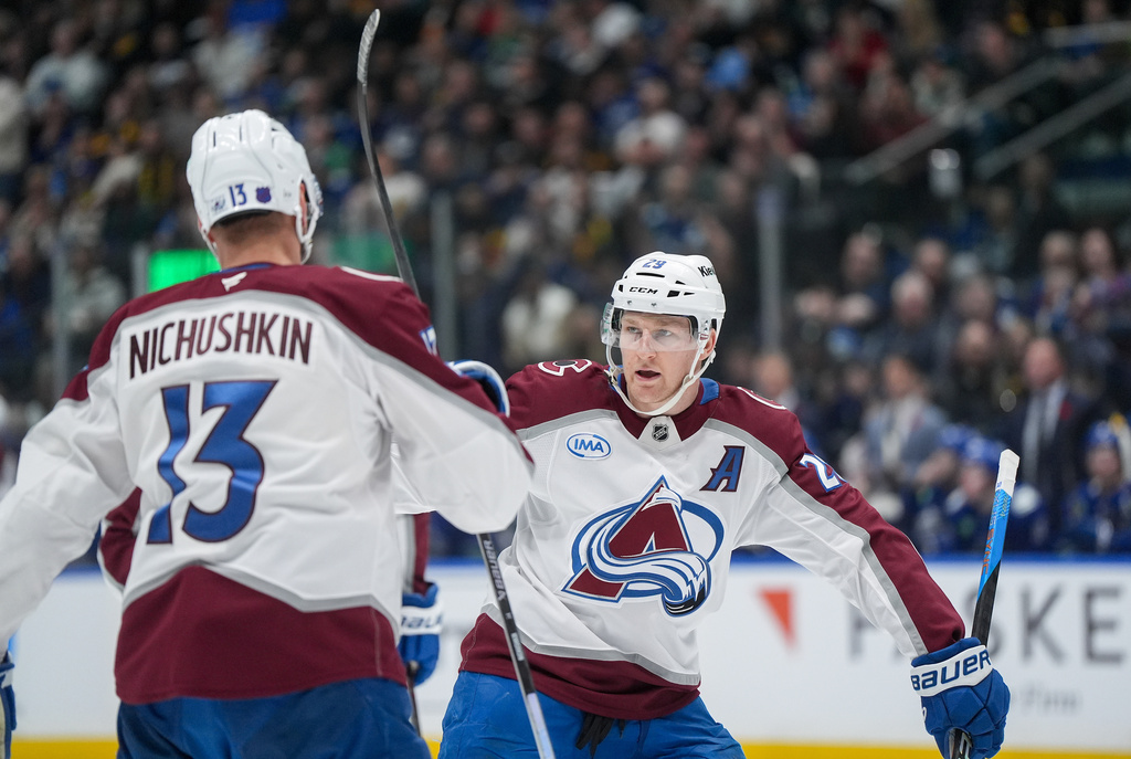Colorado Avalanche's Nathan MacKinnon (29) celebrates his second goal against the Vancouver Canucks with teammate Valeri Nichushkin during the first period of an NHL hockey game, in Vancouver, B.C., Sunday, Nov. 9, 2025. (Darryl Dyck/The Canadian Press via AP)