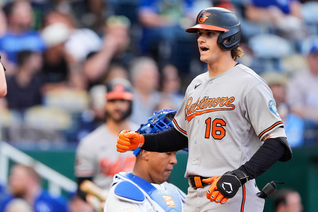 Baltimore Orioles' Coby Mayo (16) runs past Kansas City Royals catcher Salvador Perez to score after hitting a three-run home run during the second inning of a baseball game Tuesday, April 21, 2026, in Kansas City, Mo. (AP Photo/Charlie Riedel)
