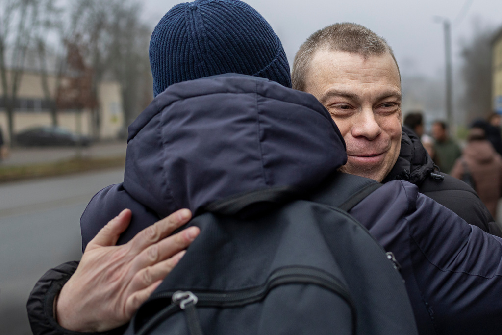 Uladzimir Labkovich, one of the released Belarusian prisoners embraces a relative as he arrives in Vilnius, Lithuania, Thursday, Dec. 18, 2025. (AP Photo/Mindaugas Kulbis)