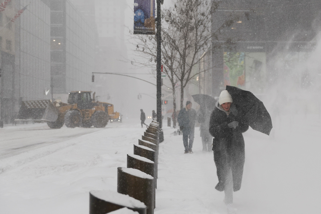 Pedestrians walk down Fifth Avenue during a winter storm, Sunday, Jan. 25, 2026, in New York. (AP Photo/Heather Khalifa)