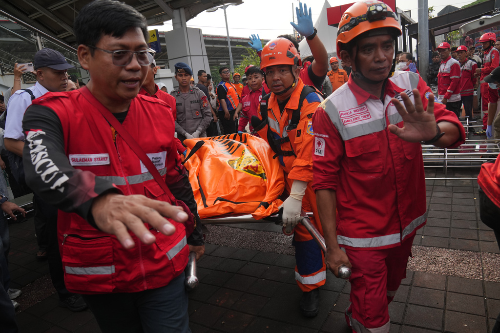 Rescuers carry the body of a victim of a train collision in Bekasi, Indonesia, Tuesday, April 28, 2026. (AP Photo/Tatan Syuflana)