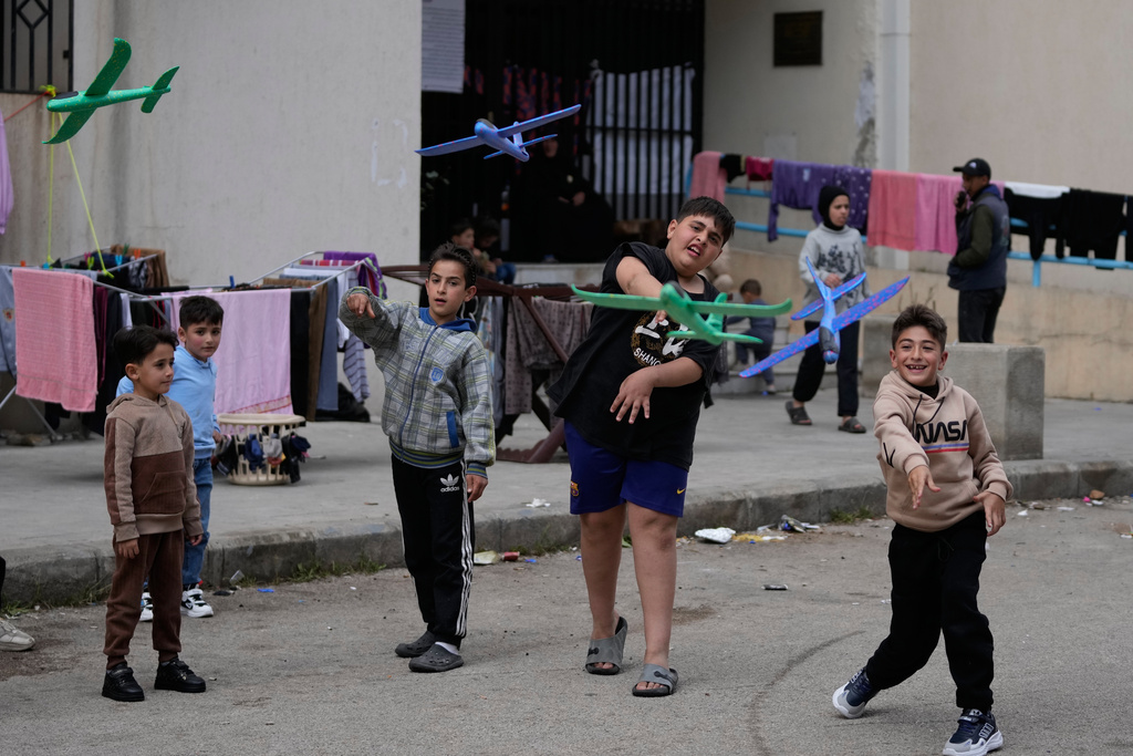 Displaced boys who fled Israeli strikes from south Lebanon, plays with toy planes at a school playground turned into a shelter, in the southern port city of Sidon, Lebanon, Monday, March 16, 2026. (AP Photo/Mohammed Zaatari)