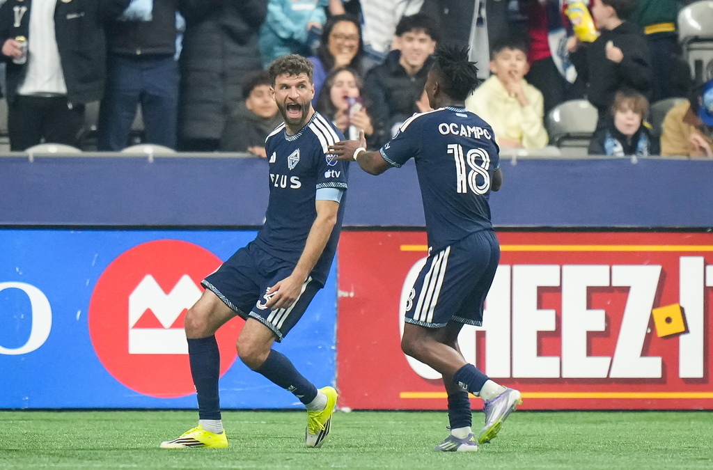 Vancouver Whitecaps' Thomas Muller, left, and Edier Ocampo celebrate Muller's second goal against Toronto FC during the first half of an MLS soccer match, in Vancouver, on Saturday, Feb. 28, 2026. (Darryl Dyck/The Canadian Press via AP)