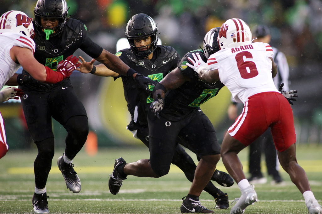 Oregon quarterback Dante Moore (5) runs the ball during the first half of an NCAA college football game against Wisconsin, Saturday, Oct. 25, 2025, in Eugene, Ore. (AP Photo/Lydia Ely)