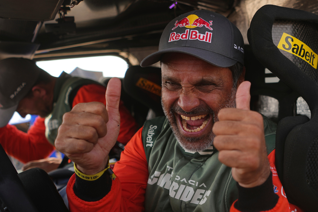Driver Nasser Al-Attiyah of Qatar, right, and co-driver Fabian Lurquin of Belgium celebrate winning the Dakar Rally after the thirteenth stage with a start and finish in Yanbu, Saudi Arabia, Saturday, Jan.17, 2026. (AP Photo/Thibault Camus)