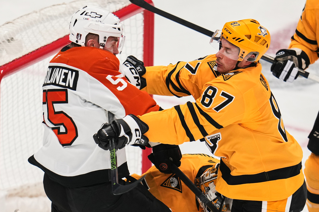 Pittsburgh Penguins' Sidney Crosby (87) checks Philadelphia Flyers' Rasmus Ristolainen (55) in front of Penguins goalie Stuart Skinner, center bottom, during the first period of Game 2 in the first round of the NHL Stanley Cup playoffs in Pittsburgh, Monday, April 20, 2026. (AP Photo/Gene J. Puskar)