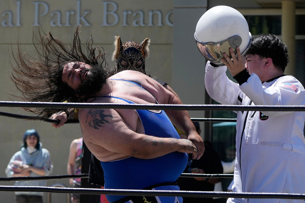 Wrestler Victor Von Richter, left, reacts after being hit by Astro Knox, right, in a Lucha Libro pro wrestling match at the San Jose Public Library Educational Park Branch Saturday, May 9, 2026, in San Jose, Calif. (AP Photo/Jeff Chiu)