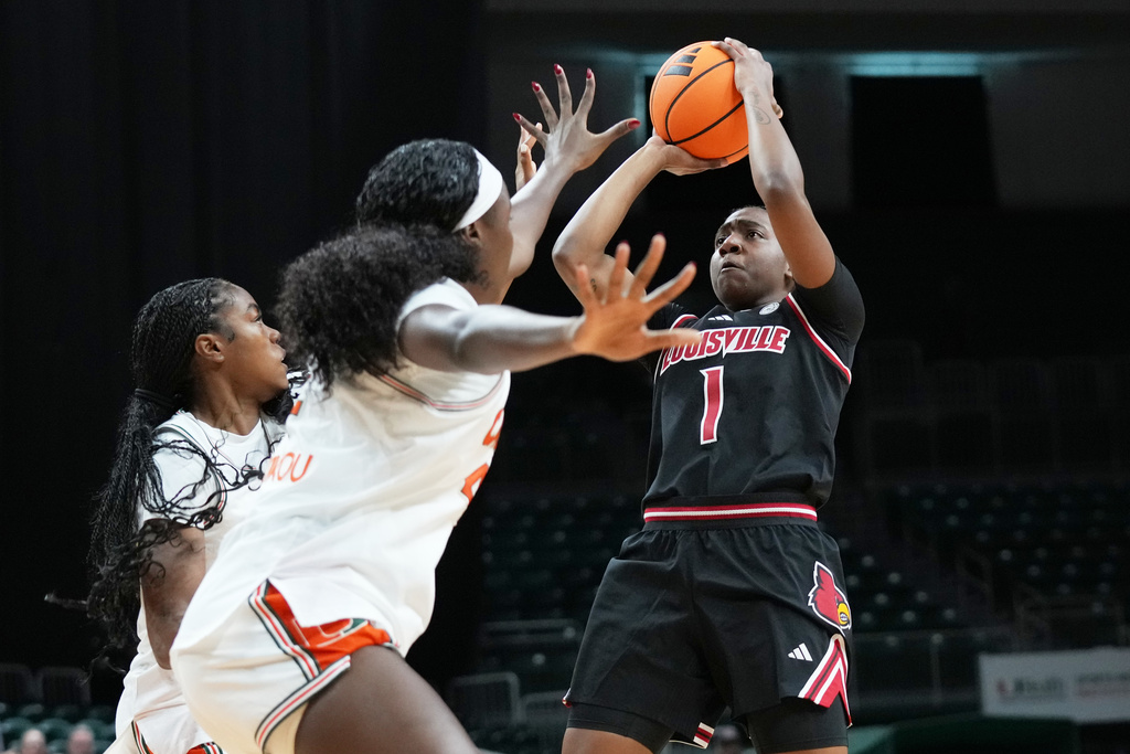 Louisville guard Reyna Scott (1) shoots as Miami center Candace Kpetikou, center, defends during the first half of an NCAA college basketball game, Thursday, Jan. 8, 2026, in Coral Gables, Fla. (AP Photo/Lynne Sladky)