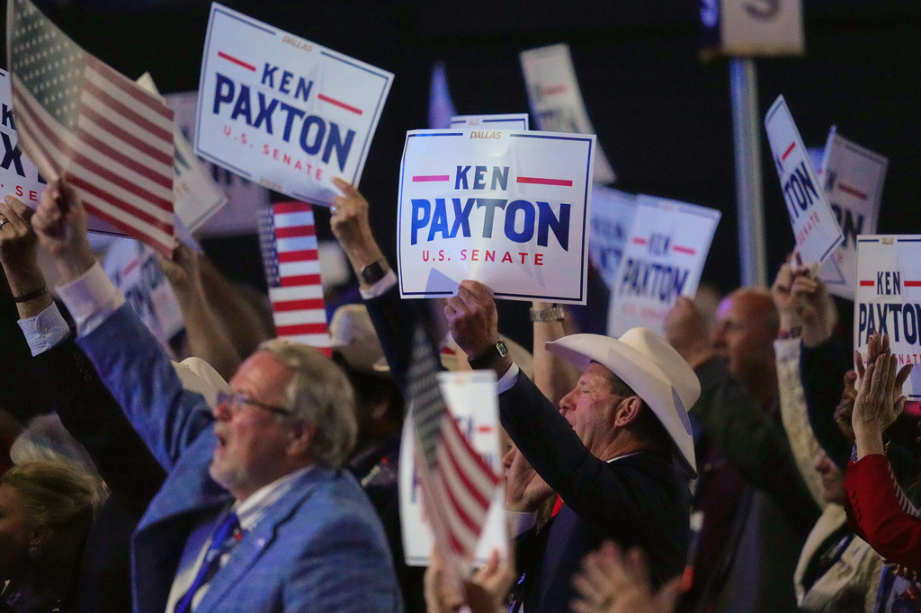 Attendees hold posters for Ken Paxton as they cheer while President Donald Trump speaks at the Republican convention Wednesday, Sept. 9, 2026, in Dallas. (AP Photo/Julio Cortez)