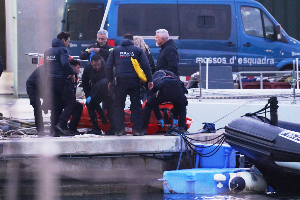 Police officers carry the body of a person found in the waters off the Port of Barcelona, Spain, Thursday, March 19, 2026. (AP Photo/Alfonso Beato)