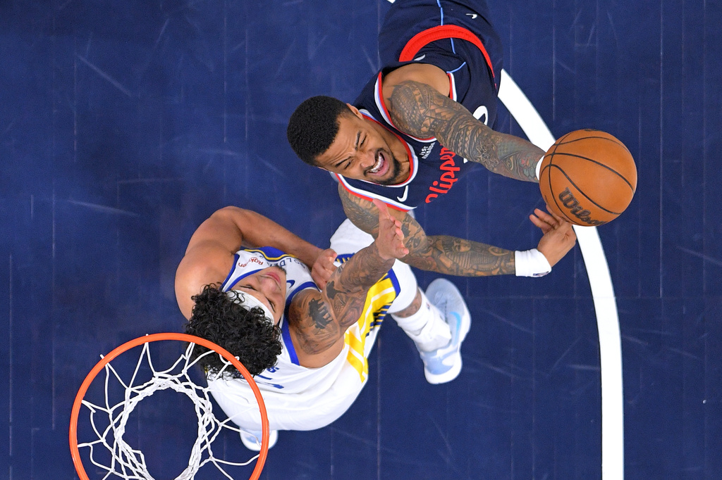 FILE - LA Clippers forward John Collins, right, shoots as Golden State Warriors forward Gui Santos defends during the first half of an NBA play-in tournament basketball game April 15, 2026, in Inglewood, Calif. (AP Photo/Mark J. Terrill, File)