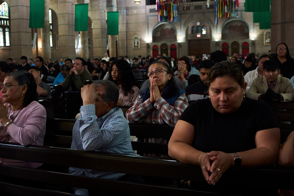Parishioners pray during a Sunday Mass at the Shrine of the Sacred Heart Catholic church in Washington, Oct. 12, 2025. (AP Photo/Luis Andres Henao)