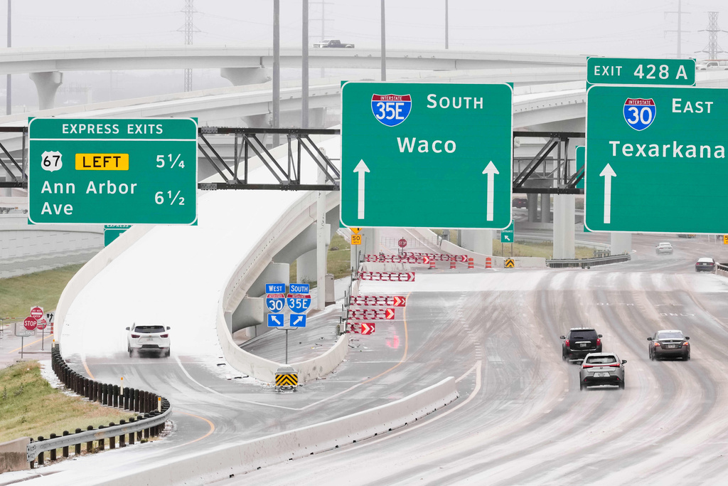Drivers navigate icy and wet road conditions by the I35-I30 interchange Saturday, Jan. 24, 2026, in Dallas. (AP Photo/Tony Gutierrez)