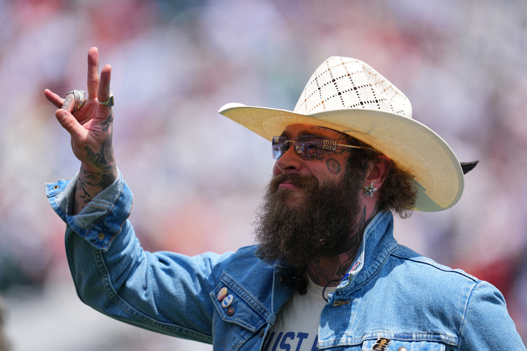 Post Malone waves during the pregame closing ceremony before the World Cup final soccer match between Spain and Argentina in East Rutherford, N.J., near New York, Sunday, July 19, 2026. (AP Photo/Julio Cortez)