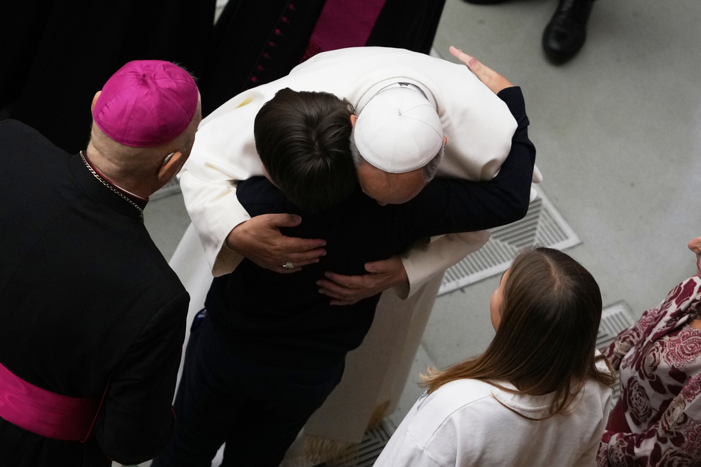 Pope Leo XIV hugs a child at the end of an audience with donors of the Christmas tree and nativity scene set up in St. Peter's Square, in the Paul VI Hall, at the Vatican, Monday, Dec. 15, 2025. (AP Photo/Alessandra Tarantino)