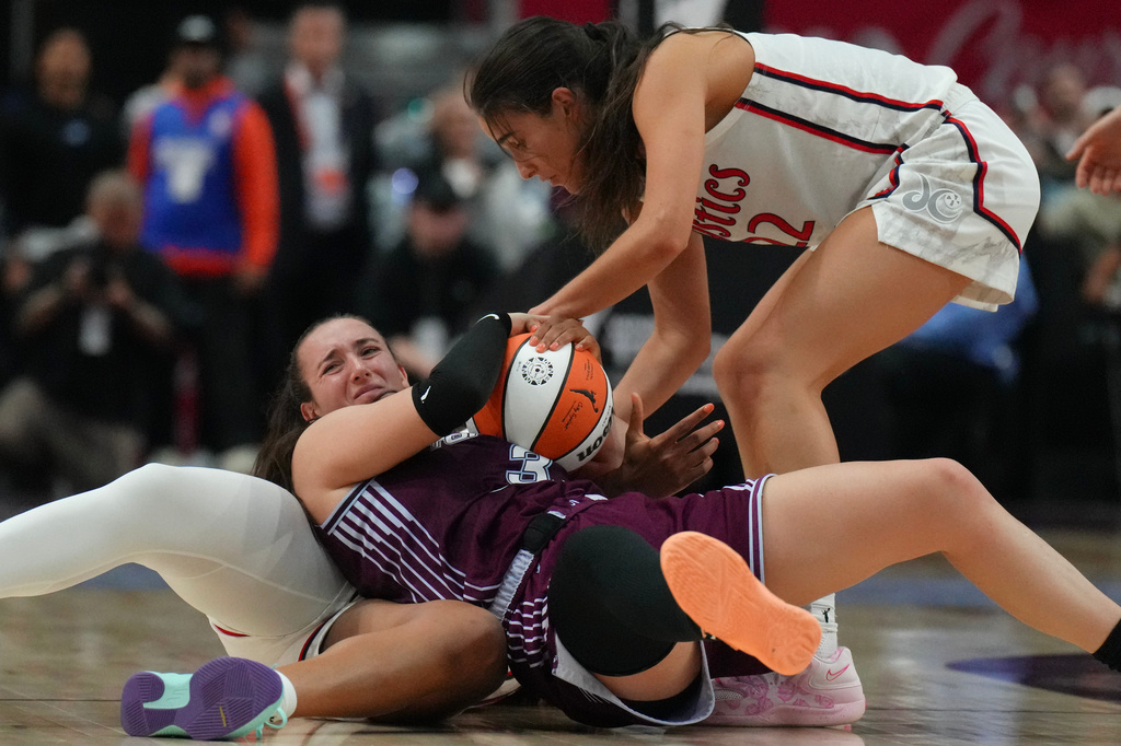 Toronto Tempo's Marina Mabrey, center, wrestles for the ball with Washington Mystics' Sonia Citron (22) and Kiki Iriafen, bottom, during second-half WNBA basketball game action in Toronto, Friday, May 8, 2026. (Chris Young/The Canadian Press via AP)