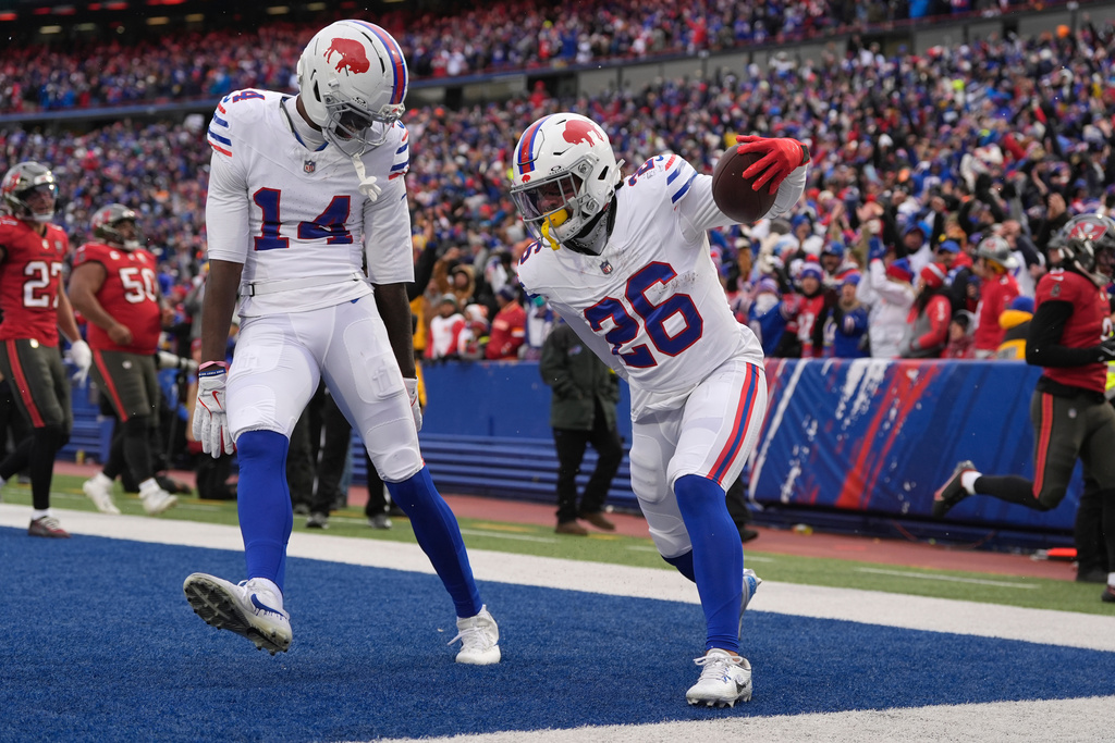 Buffalo Bills running back Ty Johnson (26) celebrates with wide receiver Tyrell Shavers (14) after scoring a touchdown against the Tampa Bay Buccaneers during the first half of an NFL football game, Sunday, Nov. 16, 2025, in Orchard Park, N.Y. (AP Photo/Carolyn Kaster)