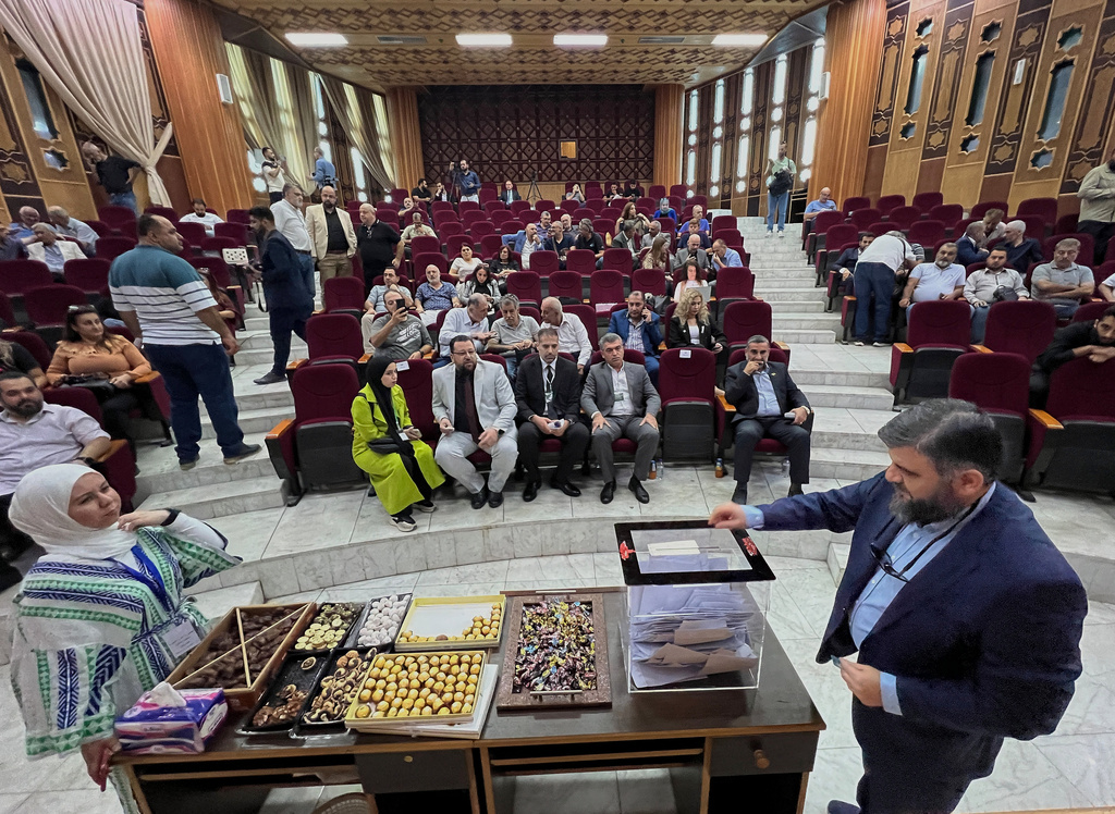 A Syrian electoral college member, right, casts his vote during the parliamentary elections at Latakia's Governor ballot station, in the coastal city of Latakia, Syria, Sunday, Oct. 5, 2025. (AP Photo/Hussein Malla)