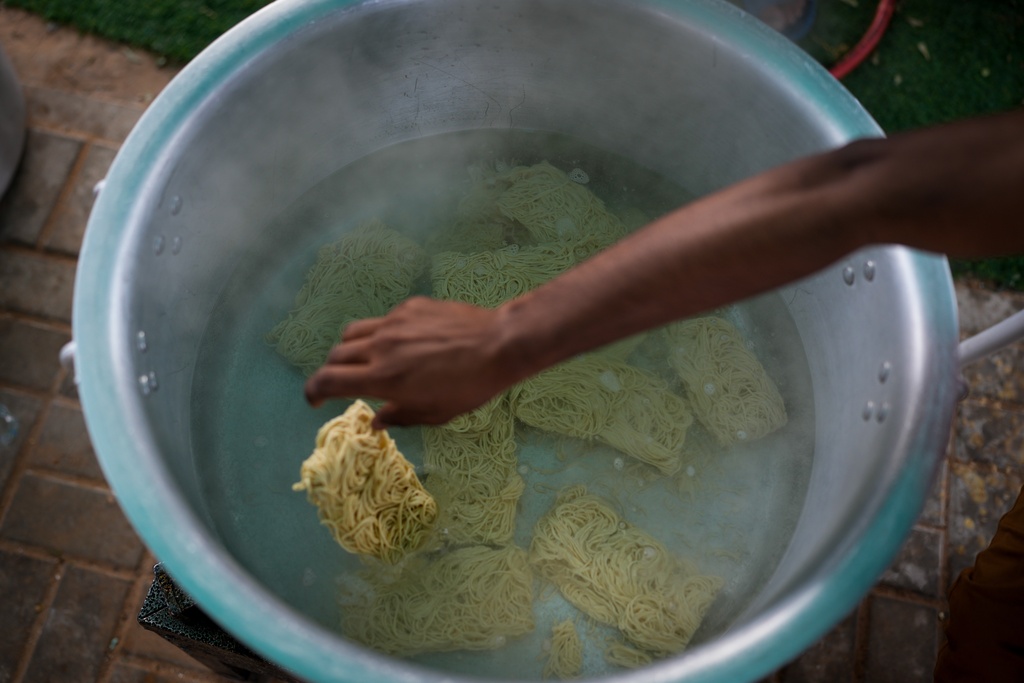 Farmhouse staff prepare food for stranded Indian travelers at a farmhouse owned by an Indian businessman, now converted into a shelter in Ajman, near Dubai, United Arab Emirates, Saturday, March 7, 2026. (AP Photo/Altaf Qadri)