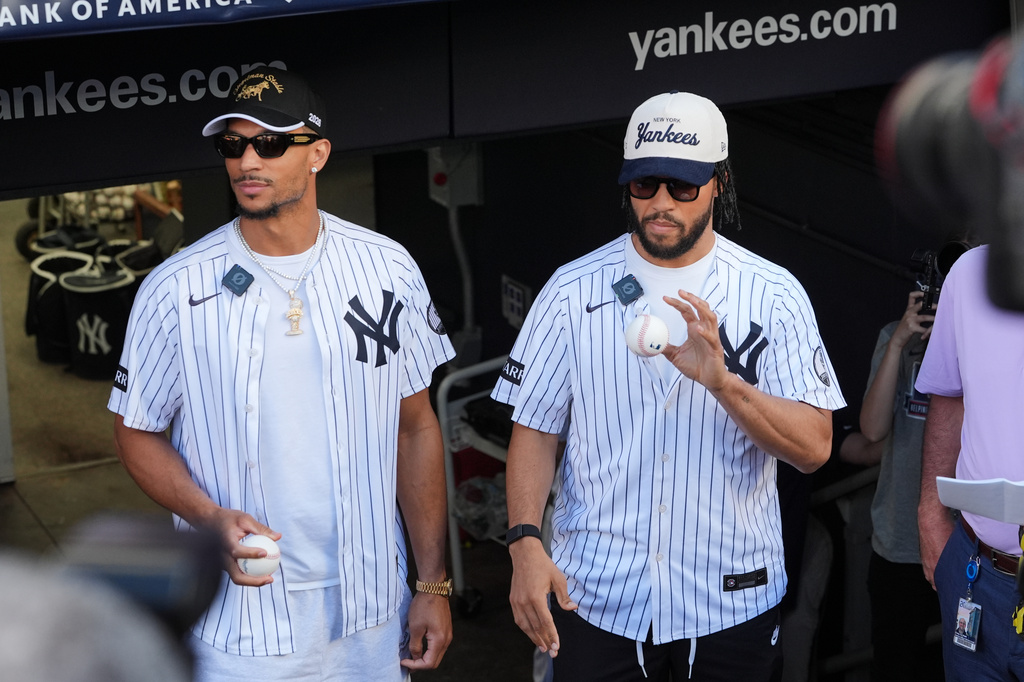 New York Knicks' Josh Hart, left, and Jalen Brunson, right, wait to throw out a ceremonial first pitch before a baseball game between the Chicago White Sox and the New York Yankees Wednesday, June 17, 2026, in New York. (AP Photo/Frank Franklin II)