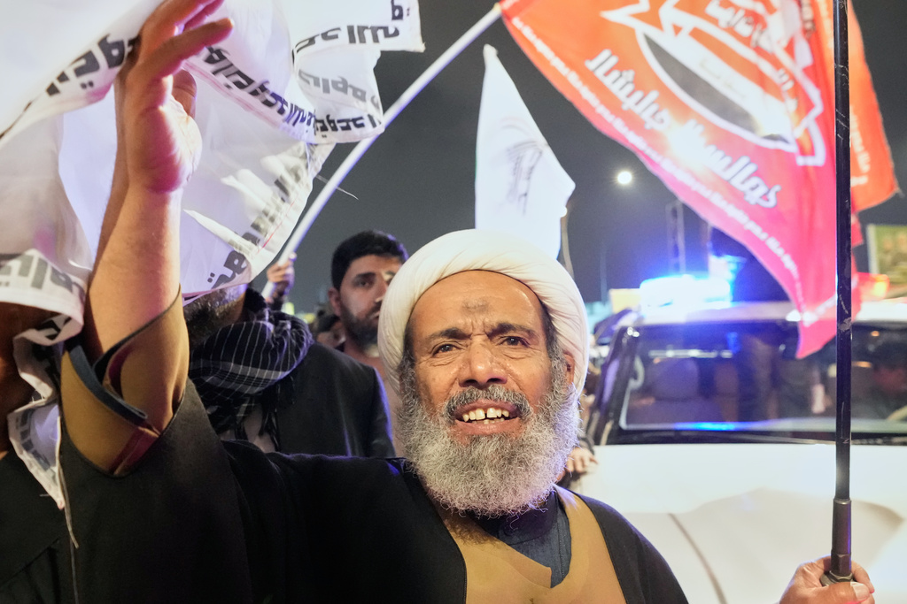 Relatives grieve in Baghdad, Iraq, on Thursday, March 12, 2026, during a funeral for members of the Popular Mobilization Forces who were killed in a U.S. airstrike in Qaim. (AP Photo/Hadi Mizban)