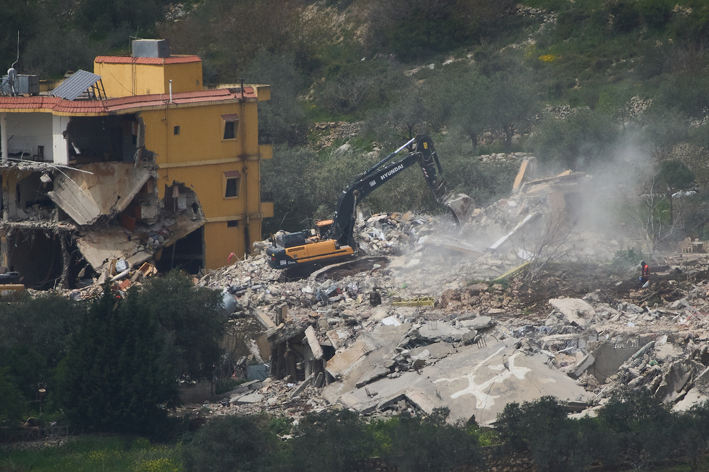 Israeli bulldozers demolish homes in southern Lebanon, as seen from northern Israel, Sunday, April 12, 2026. (AP Photo/Ariel Schalit)