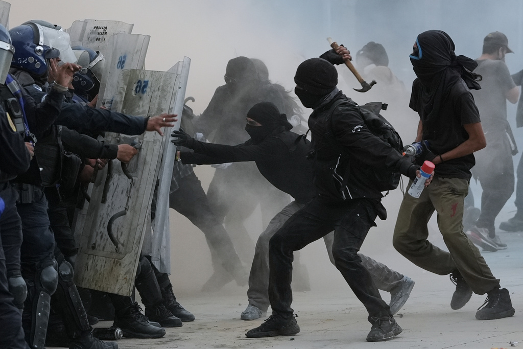 Demonstrators and riot police face off during a protest commemorating the anniversary of the 1968 Tlatelolco killings, when soldiers fired on student protesters, in Mexico City, Thursday, Oct. 2, 2025. (AP Photo/Claudia Rosel)