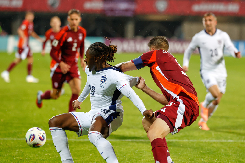 England's Eberechi Eze is pulled back by Latvia's Antonijs Cernomordijs during the 2026 World Cup group K qualifying soccer match between Latvia and England in Riga, Latvia, Tuesday, Oct. 14, 2025. (AP Photo/Mindaugas Kulbis)