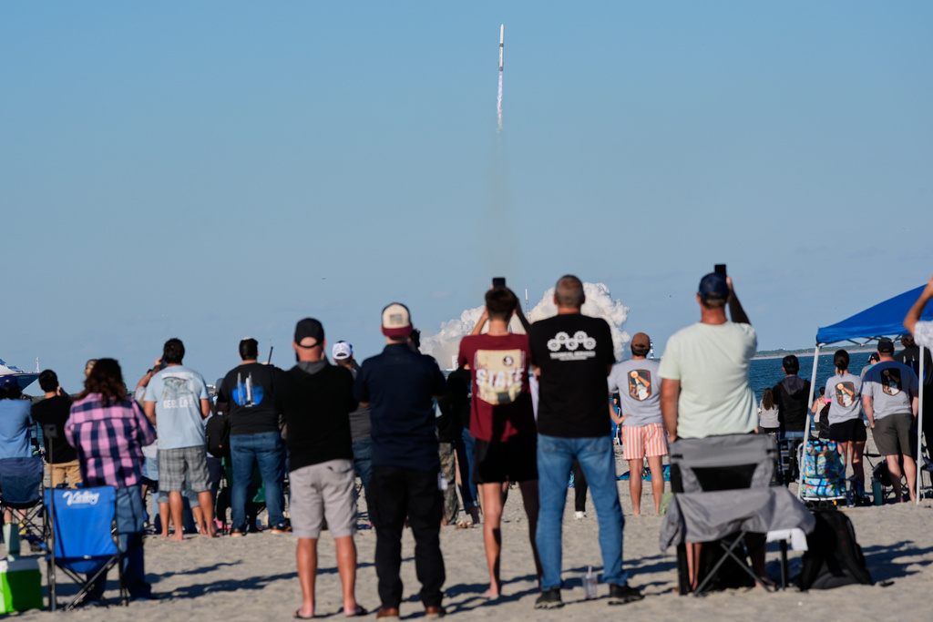 Spectators on the beach watch a Blue Origin New Glenn rocket as it lifts off from Launch Complex 36 at the Cape Canaveral Space Force Station in Cape Canaveral, Fla., Thursday, Nov. 13, 2025. (AP Photo/John Raoux)