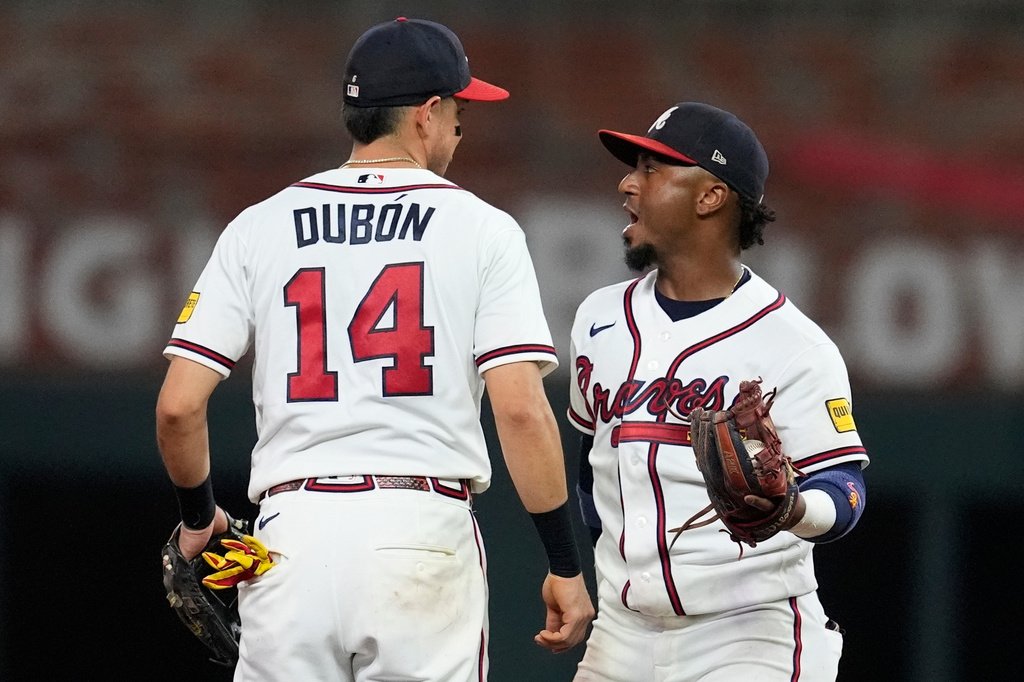 Atlanta Braves' Mauricio Dubón (14) and Ozzie Albies (1) celebrate a win over the New York Mets after a baseball game, Wednesday, Aug. 12, 2026, in Atlanta. (AP Photo/Mike Stewart)