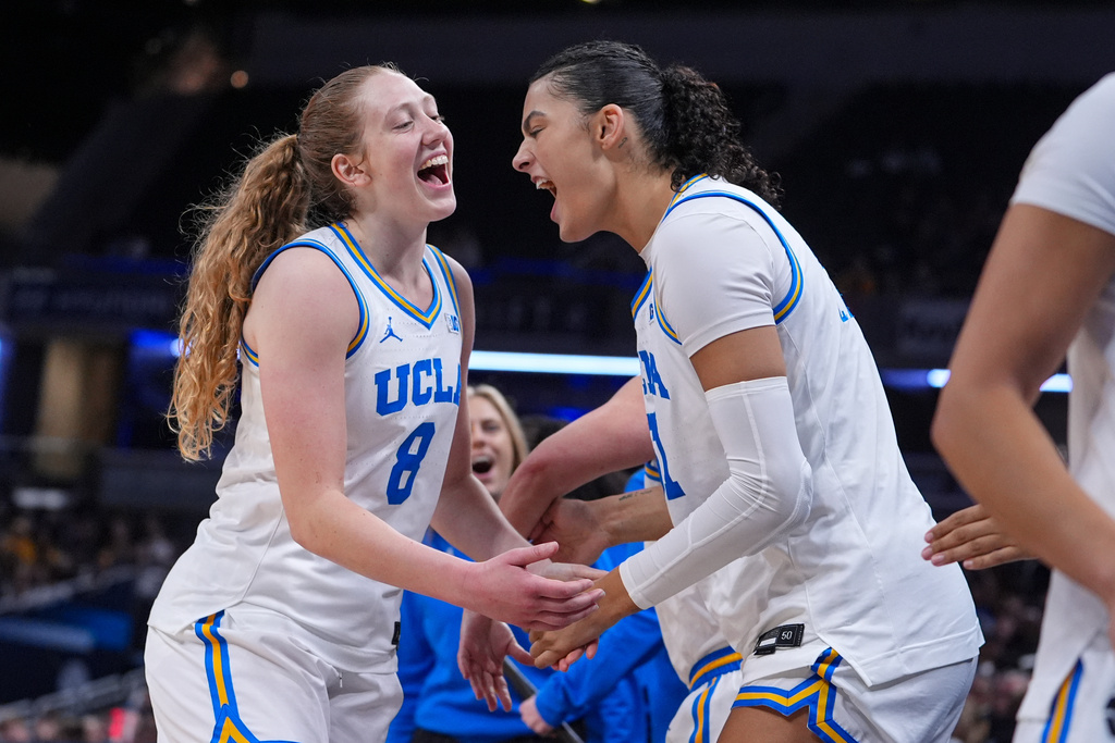 UCLA guard Gianna Kneepkens (8) and center Lauren Betts (51 celebrate on the bench in the second half of an NCAA college basketball game against Iowa in the finals of the Big Ten Conference tournament, Sunday, March 8, 2026 in Indianapolis. (AP Photo/Michael Conroy)