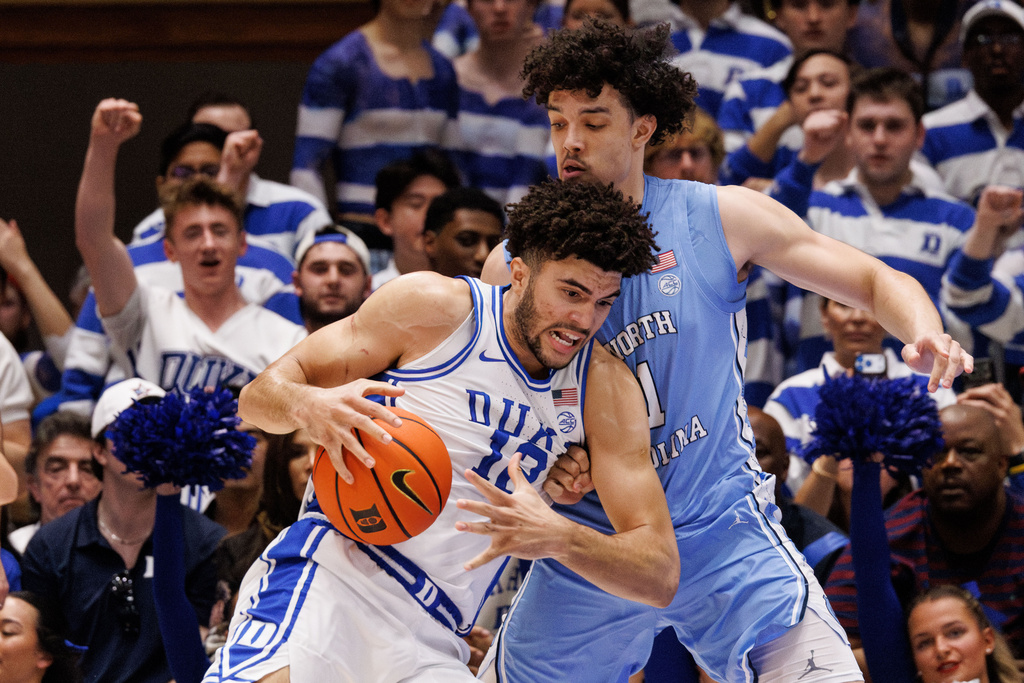 Duke's Cameron Boozer (12) handles the ball as North Carolina's Zayden High, right, defends during the first half of an NCAA college basketball game in Durham, N.C., Saturday, March 7, 2026. (AP Photo/Ben McKeown)