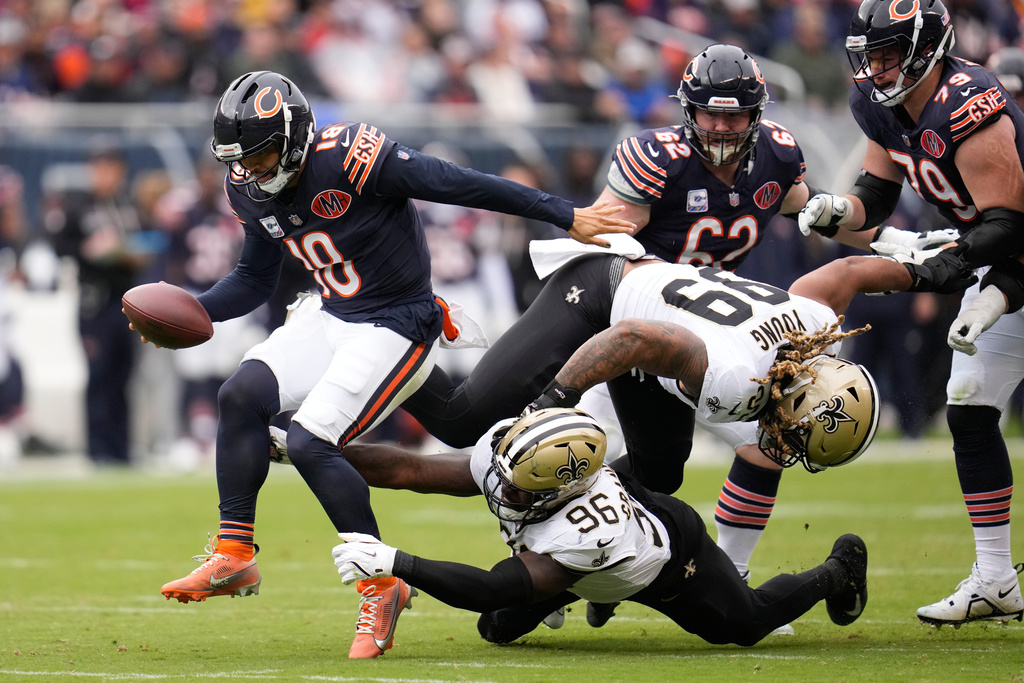 Chicago Bears quarterback Caleb Williams (18) avoids a tackle by New Orleans Saints defensive end Carl Granderson (96) in the first half of an NFL football game, Sunday, Oct. 19, 2025, in Chicago. (AP Photo/Erin Hooley)